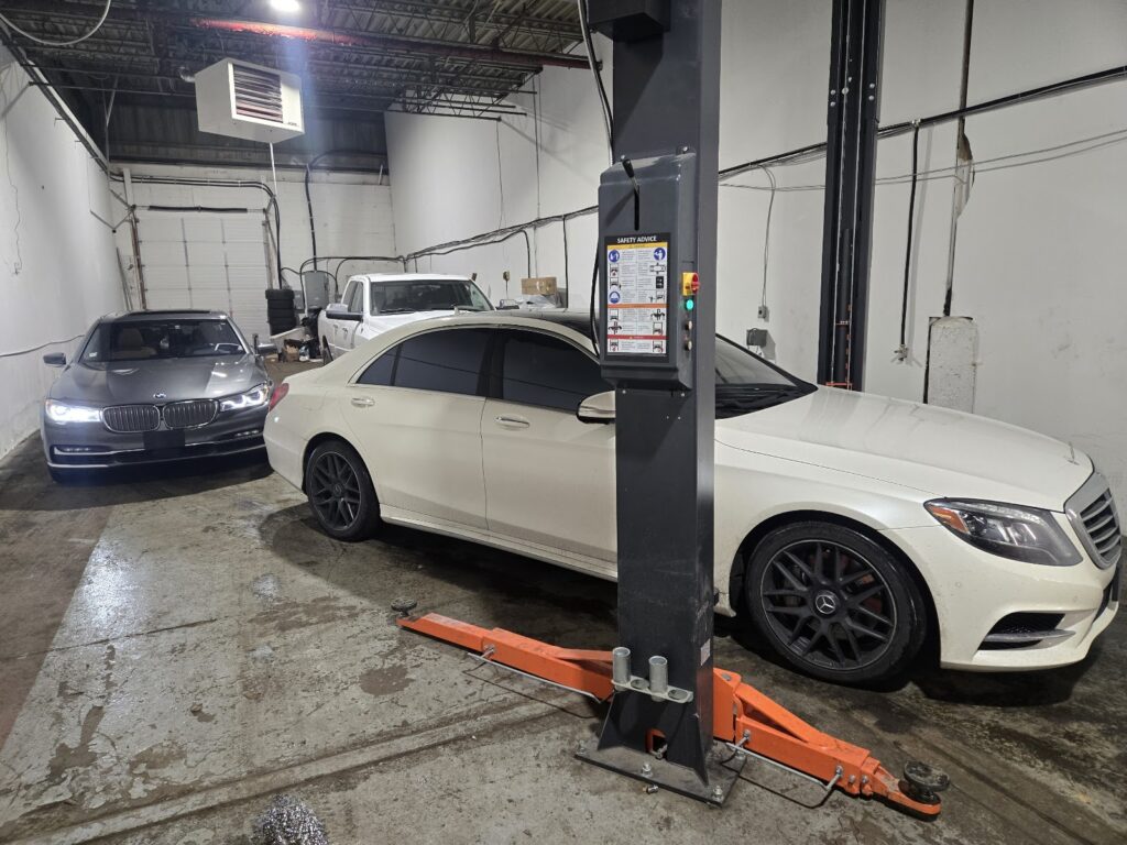 Vehicle hoists inside the Shah Motors auto repair and DriveON safety inspection workshop in Mississauga